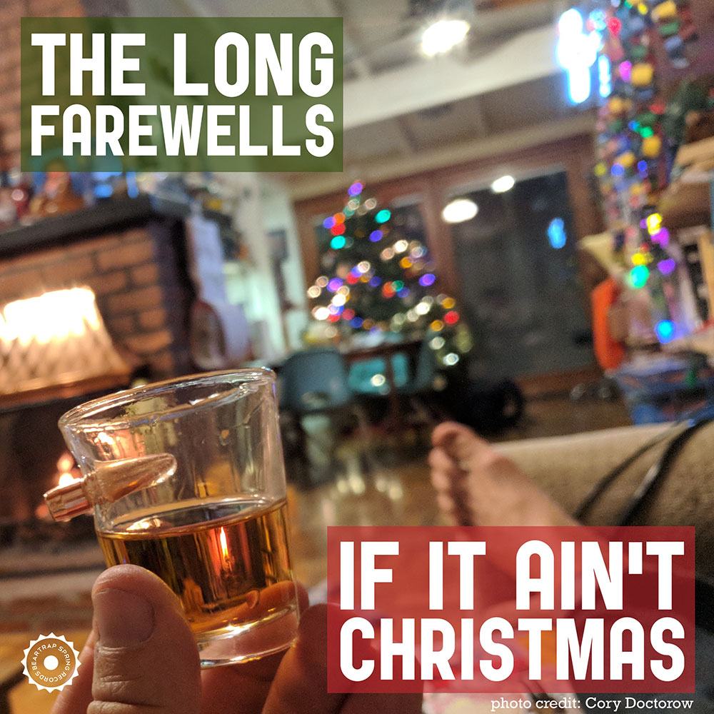 If It Ain't Christmas cover art: in the foreground a hand holding a shotglass of whiskey, with blurry Christmas trees in the background
